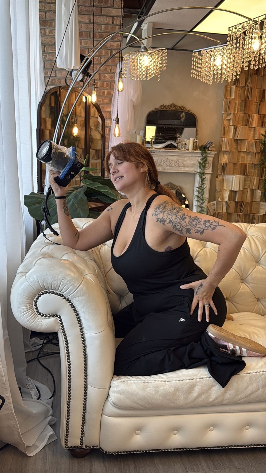 Bri Valiente behind the camera on the white couch set in her Chicago boudoir studio