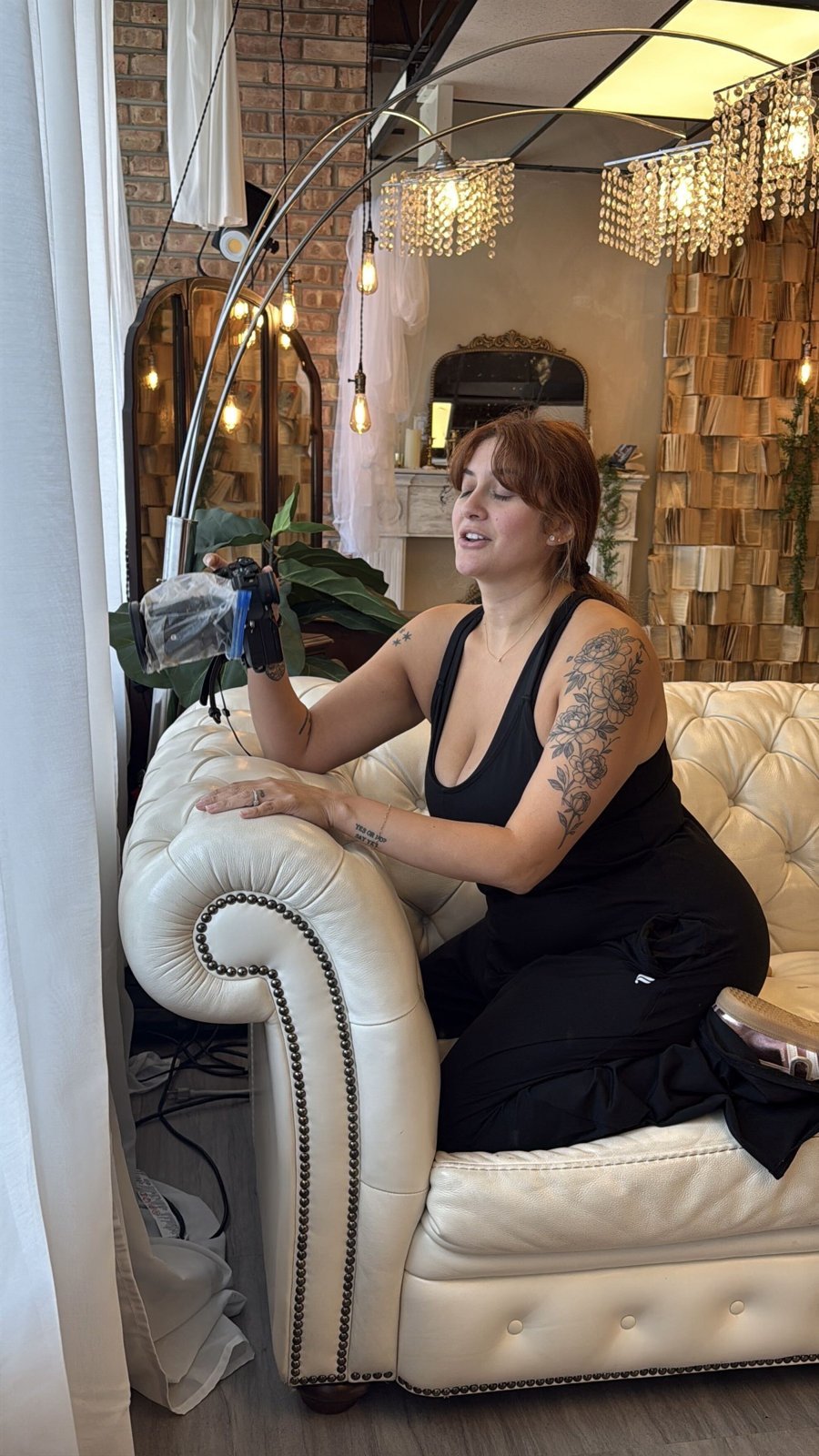 Bri Valiente behind the camera on the white couch set in her Chicago boudoir studio