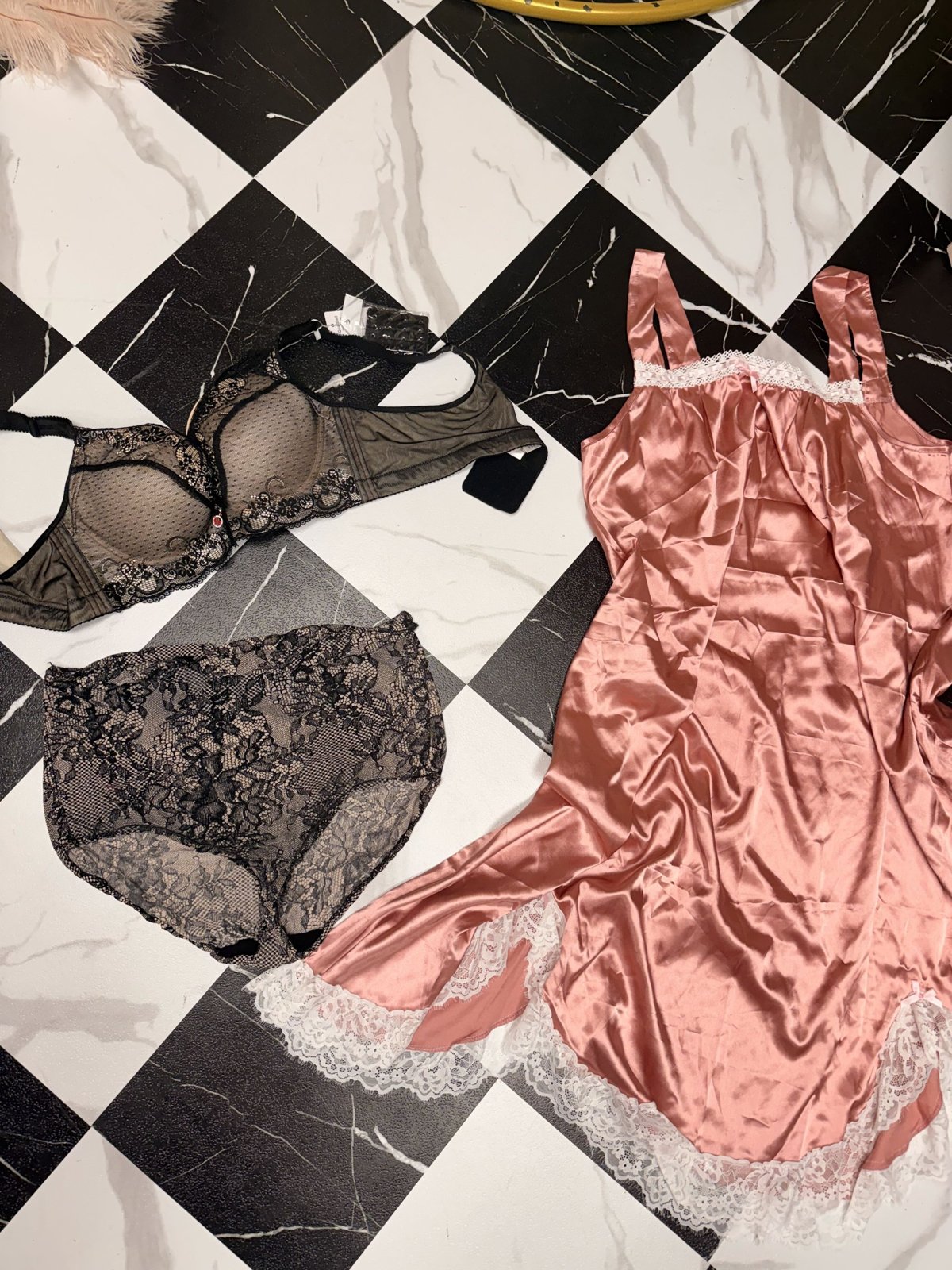 Pink satin slip with black lace lingerie on the checkered floor of Bri Valiente Boudoir in Chicago