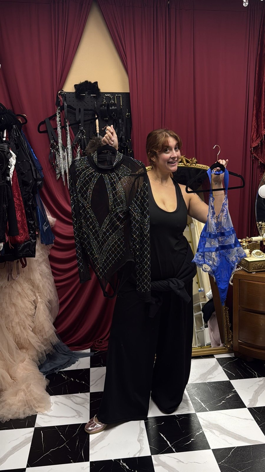 Bri Valiente holding two outfit options in her Chicago boudoir client closet